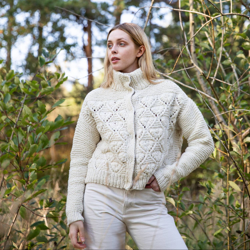 Woman wearing a cream knitted cardigan in a forest setting