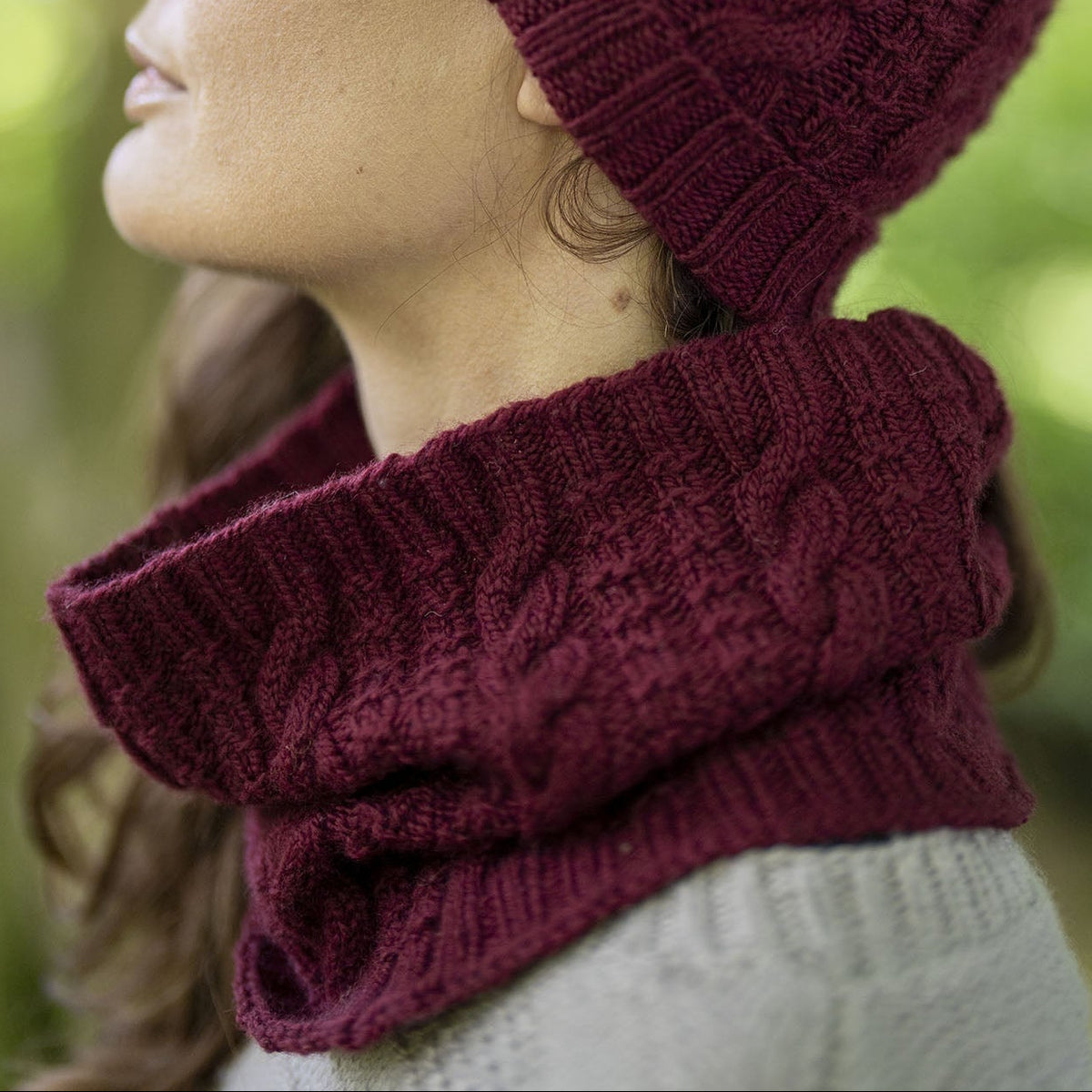 Side view of the Darvel Cabled Cowl in deep burgundy Orry Yarn Merino DK.