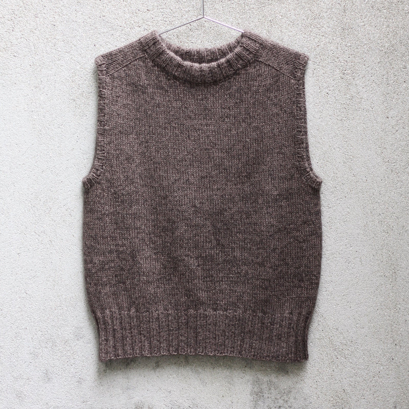 The Knitting for Olive Olive's Vest slipover laid flat, showing the ribbed neckband, armhole edges and hem