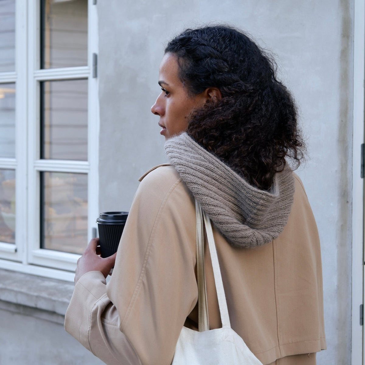 Woman wearing the Knitting for Olive Alex Hood with the hood down like an ordinary scarf