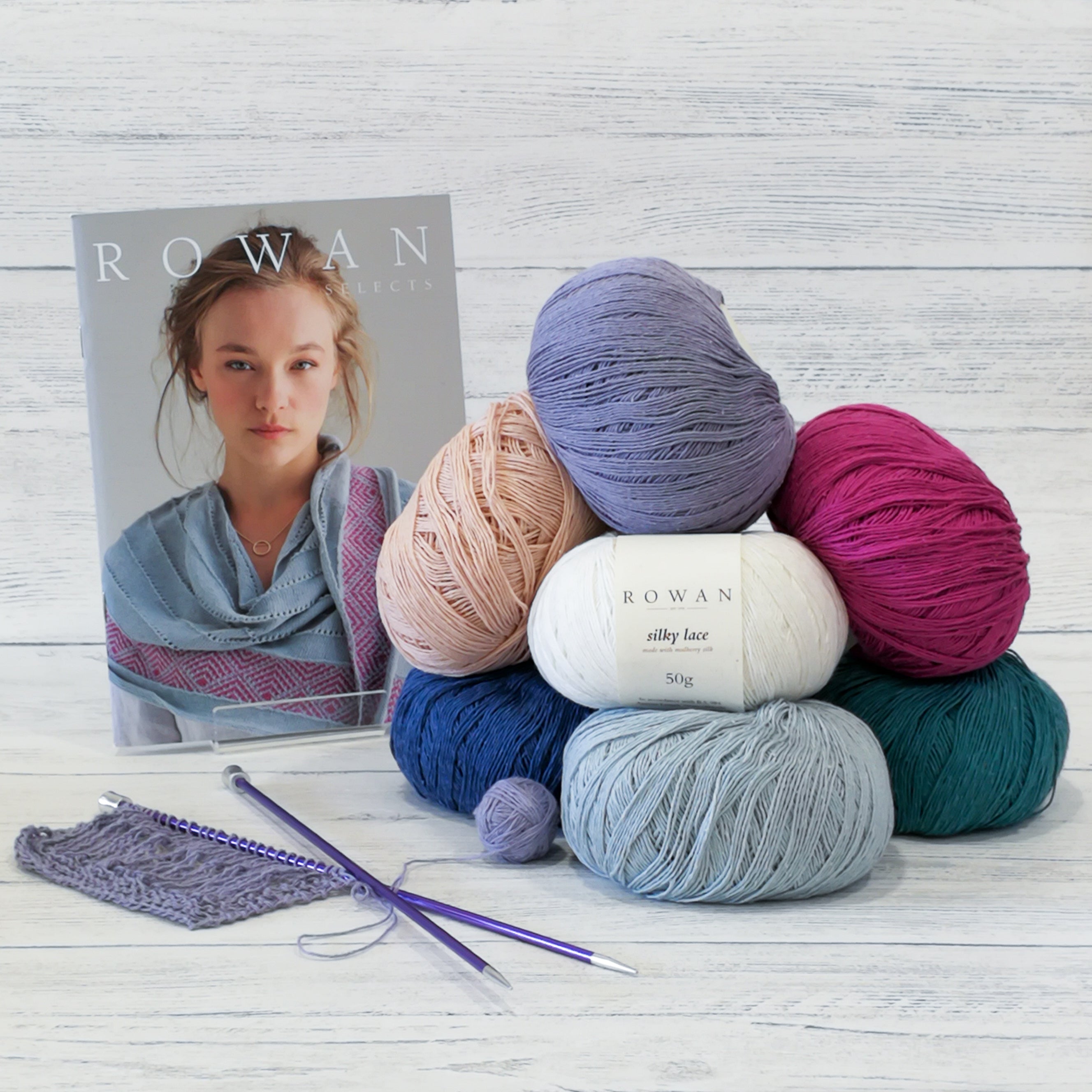 Stack of Rowan wool, knitting needles and Rowan pattern book