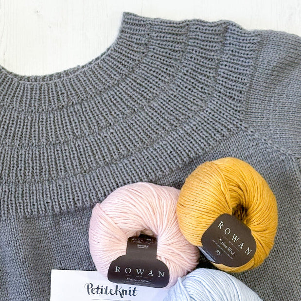 A knitting kit for a summer shirt displayed with yarns in various colors and a printed pattern.