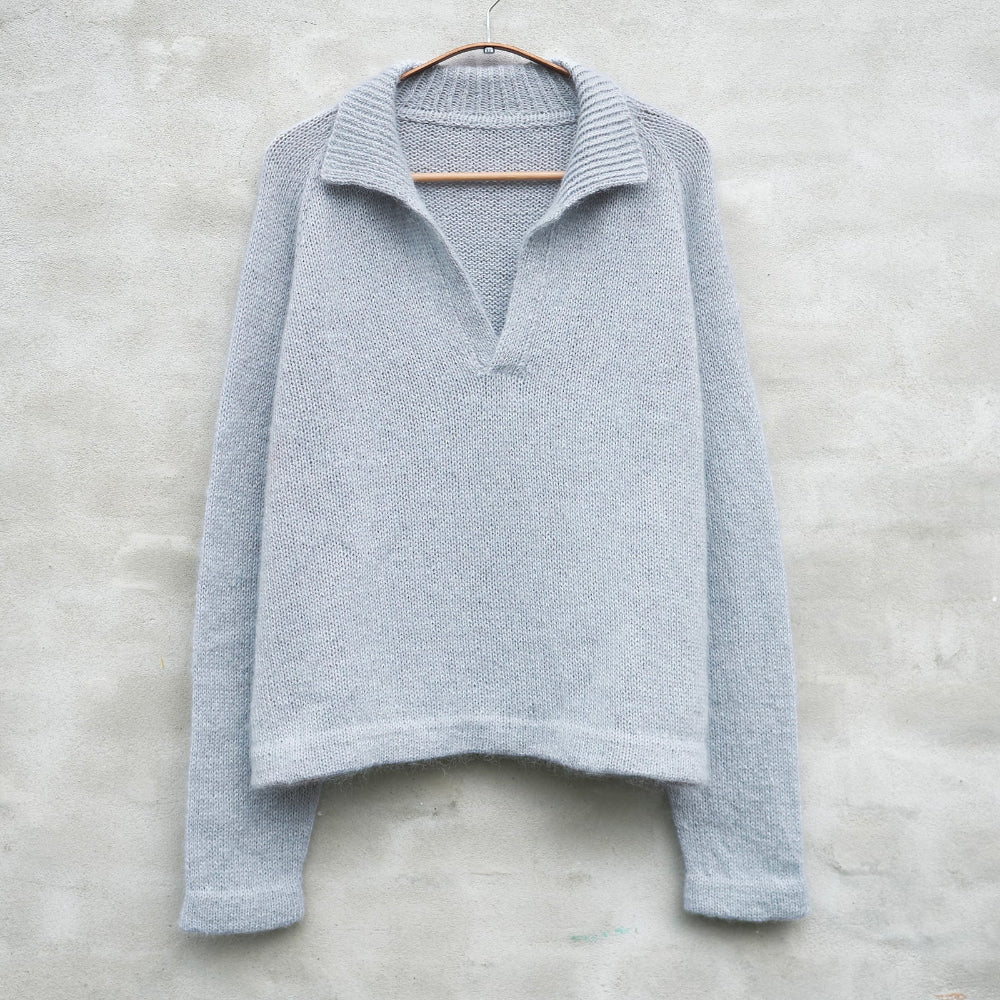Pale Blue Knitting for Olive Wilson Sweater on a hanger against a light gray background